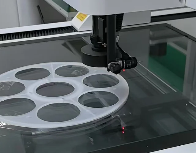 CMM probe inspecting circular precision parts on a measurement table